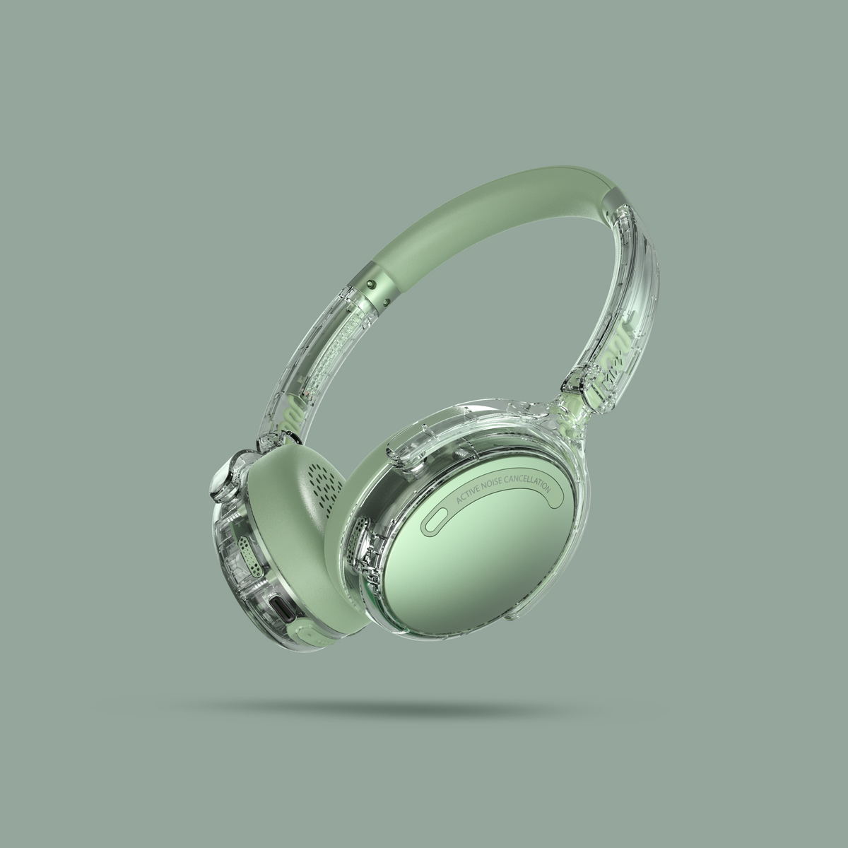 Light green over-ear headphones with clear plastic outer shells, shown floating against a solid muted sage green background.